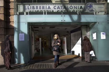 Dos personas leyendo ayer la nota del cierre de la librer&iacute;a Catal&ograve;nia colgada en la puerta.