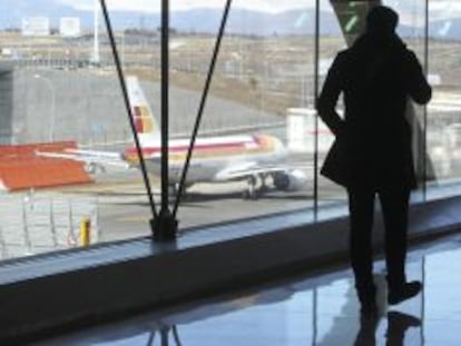 Un pasajero observa un avi&oacute;n de Iberia en el aeropuerto de Madrid. 