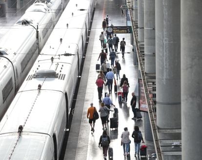 Varios pasajeros con maletas en el andén de un tren en la estación de Puerta de Atocha, el viernes pasado en Madrid.