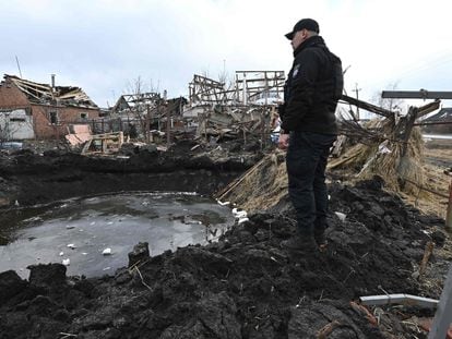 Un policía examina un cráter después del bombardeo ruso en Vovchans'k, este jueves.