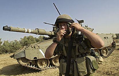 Un soldado israelí, junto a un carro de combate en la franja de Gaza.