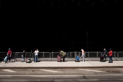Habitantes del barrio de Brooklyn, en Nueva York ( EE UU), hacen cola para recibir paquetes de alimentos del Banco de Alimentos de la ciudad.
