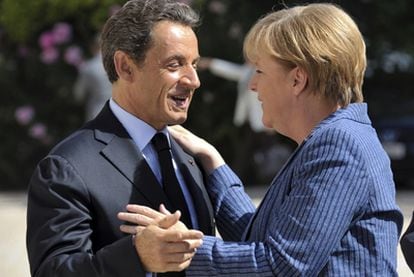 Nicolas Sarkozy y Angela Merkel se saludan antes del encuentro de ayer  en El Elíseo, en París.
