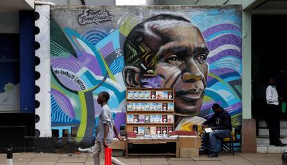Un hombre pasea junto a un graffiti con el poseedor del récord mundial de maratón de Kenia Eliud Kipchoge en una avenida en el centro de Nairobi, Kenia.