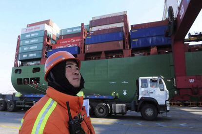 Un operario del puerto de la ciudad china de Qingdao cerca de un buque portacontenedores.