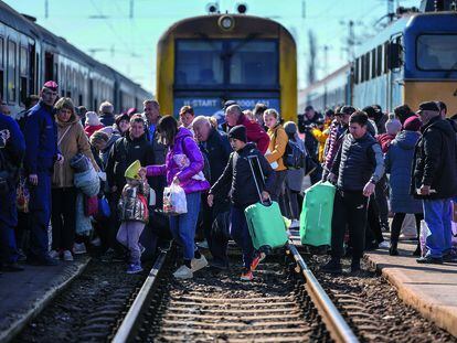 Refugiados ucranios cruzan las vías del tren en Zahony, Hungría.