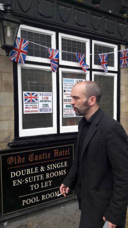 Un ciudadano pasa junto a un hotel con carteles que celebran el 'Brexit'.