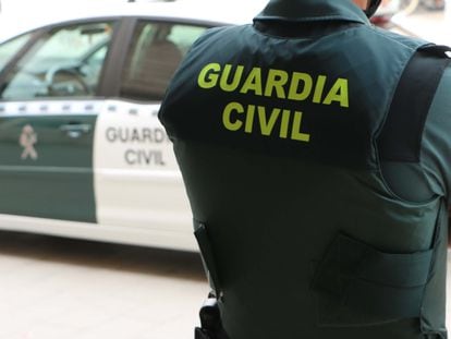 Un agente de la Guardia Civil, de espaldas, junto a un vehículo oficial en una imagen de archivo.