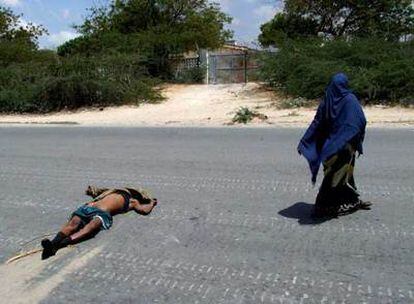 Una mujer somalí pasa junto al cadáver de un soldado etíope muerto a tiros en Mogadiscio en los combates del viernes.