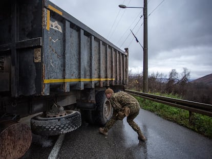 Un soldado letón, miembro de las fuerzas de la OTAN desplegadas en Kosovo, inspecciona este domingo un camión que bloquea una de las principales carreteras que conducen a la frontera con Serbia.