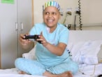 Una niña con cáncer juega a un videojuego en su habitación del hospital.