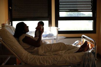 Una mujer sostiene a su hija reci&eacute;n nacida en el hospital Sandro Pertini de Roma.