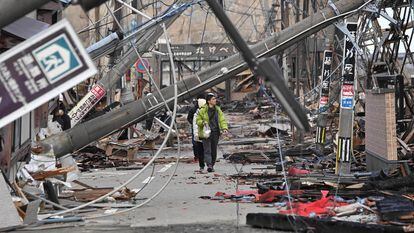 Varias personas caminan entre postes caídos por el terremoto de Año Nuevo, en la ciudad de Wajima (prefectura de Ishikawa), el 4 de enero.