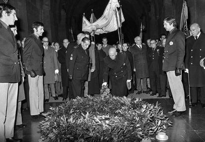Franco, acompañado por el entonces príncipe Juan Carlos de Borbón (detrás), deposita flores sobre la tumba de Primo de Rivera, durante el funeral celebrado en el Valle de los Caídos en el 38 aniversario de su muerte.