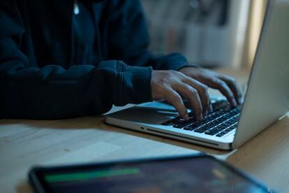 Un programador escribiendo en el teclado portátil para registrar el sistema de datos.