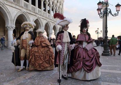 Un grupo de parejas disfrazadas de época paseando por la plaza de San Marcos de Venecia.