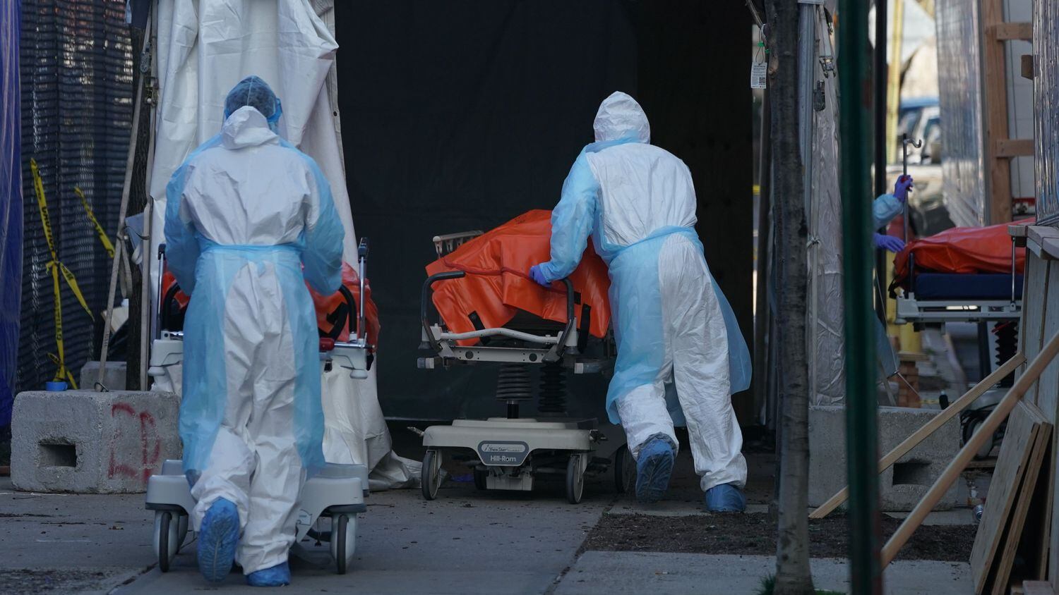 Unos trabajadores de un hospital de Brooklyn (Nueva York, EEUU) trasladan cadáveres a un camión frigorífico.