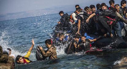 Migrantes saltan de una lancha neum&aacute;tica tras lograr alcanzar la costa cerca de Skala Sikaminias, en la isla griega de Lesbos.