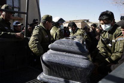 Varios policías portan el féretro con los restos de un colega muerto por una turba, en Oruro.