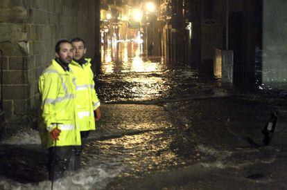 Dos funcionarios municipales observan los destrozos que ha ocasionado el temporal en la Parte Vieja de San Sebastián.