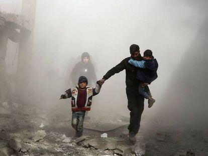 Civiles sirios huyen de los bombardeos, el jueves en Jisrin (Guta Oriental).