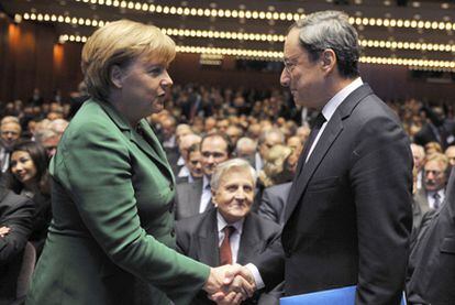 Angela Merkel saluda a Mario Draghi en la despedida de Jean Claude Trichet, en octubre.
