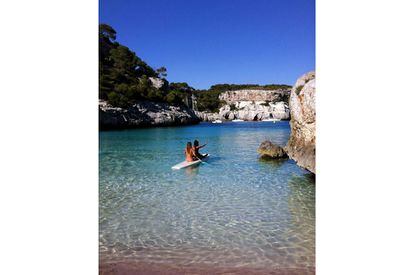 Dos chicas navegando en la cala menorquina de la Macarelleta (Baleares).