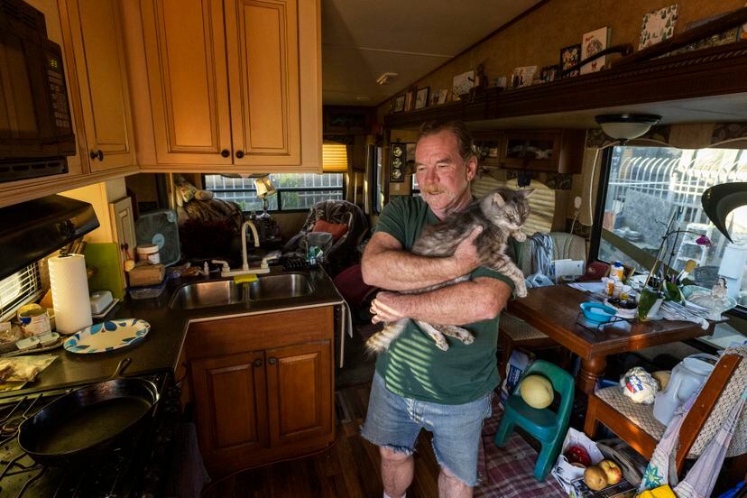 Damon, junto a su gato, en el área de autocaravanas de Candlestick, en San Francisco, donde decenas de familias viven en vehículos de forma permanente.