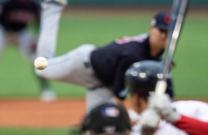 El lanzador de béisbol de los Indios de Cleveland Shane Bieber (al fondo) lanza la pelota ante Rafael Devers de los Medias Rojas, durante un encuentro de las Grandes Ligas de Béisbol celebrado en Boston (EE UU).