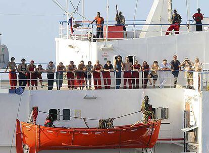 La tripulación del mercante <i>MV Faina</i>, secuestrado por piratas somalíes, espera en la cubierta del buque.