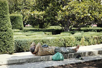 Un hombre se tumba a la sombra en la Plaza de Oriente de Madrid.