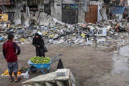 A woman is interested in fruit from a street vendor in Gaza City, this Monday.