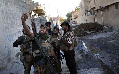 Soldados de las Fuerzas Especiales iraquíes se toman un selfi en una calle del barrio de Mosul (Irak) tras haber recuperado la zona hasta entonces controlada por el Estado Islámico, el 22 de noviembre de 2016.