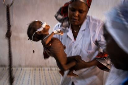 Esta es la imagen de cuando todo ha fallado. La enfermera Salamatou Badamassi pesa a un niño ingresado en cuidados intensivos, en Aguié, región de Maradi, al sur de Níger. La sequía extrema y el aumento de precios del cereal y los fertilizantes por la guerra de Ucrania aboca a media África a una crisis de hambre sin precedentes.