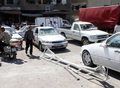 Algunos coches con los cristales rotos por el estallido de la bomba en Damasco.