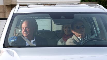 El rey Juan Carlos I (a la izquierda) saluda a su llegada a la vivienda de su anfitrión, Pedro Campos (a la derecha, al volante) en Sanxenxo (Pontevedra), este jueves. En el asiento de atrás, a la derecha, la infanta Elena.