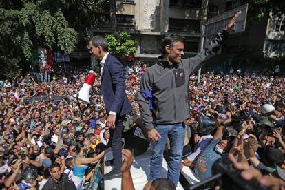 El líder opositor venezolano Juan Guaidó (izquierda) y el político opositor de alto perfil Leopoldo López, quien fue puesto bajo arresto domiciliario por el régimen del presidente venezolano Nicolás Maduro, saludan a sus partidarios.