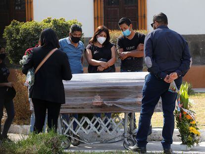 Una familia se despide de una persona fallecida por la covid-19 en un funeral en el panteón de Mezquitán en Guadalajara, estado de Jalisco (México) este lunes.