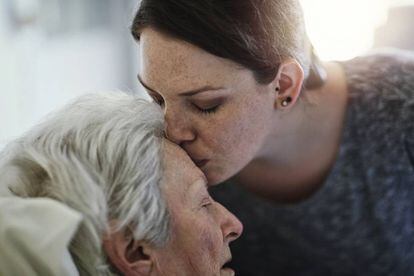 Una mujer besa a su madre en un hospital.