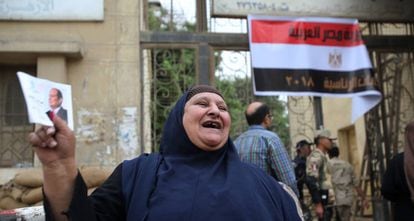 Una egipcie sostiene una foto de Abdelfatá al Sisi en la entrada de un colegio electoral en El Cairo, este miércoles.