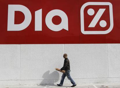 Un hombre camina delante de un supermercado de la cadena Dia