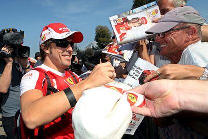 Fernando Alonso firma autógrafos ayer en Melbourne.