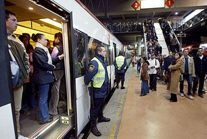 Los guardias de seguridad de la estación de Atocha controlaban ayer, como es habitual, la subida y bajada de pasajeros de los trenes de cercanías. La afluencia de viajeros era mucho menor de lo normal.
/ LUIS MAGÁN