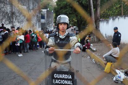 Migrantes esperan en fila afuera de las oficinas de la Comisión Mexicana de Ayuda a Refugiados (COMAR) en Tapachula, este martes.