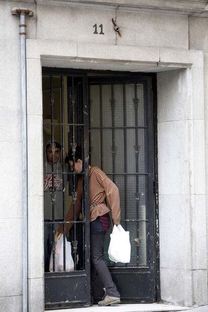 Dos de las personas que han ocupado el inmueble que hay junto al Albéniz entran en el portal del edificio.