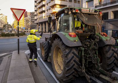 Un agente de policía local conversa con un agricultor que circula en su tractor por una calle de Logroño, este miércoles.