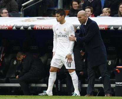 El entrenador del Real Madrid Zinedine Zidane da instrucciones a James antes de que este salga al terreno de juego durante el partido de liga entre el Real Madrid y el Sporting de Gijón disputado en el estadio Santiago Bernabéu, el 17 de enero de 2016.