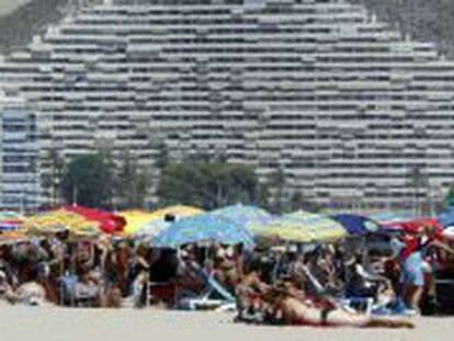 Veraneantes disfrutan al pie de los apartamentos de la playa de Cullera, en Valencia.