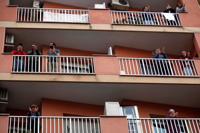 Vecinos de L'Hospitalet salen a sus balcones como cada día a animar y homenajear a los sanitarios.