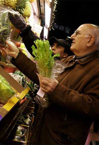 Un jubilado compra frutos frescos en un mercado de Barcelona.